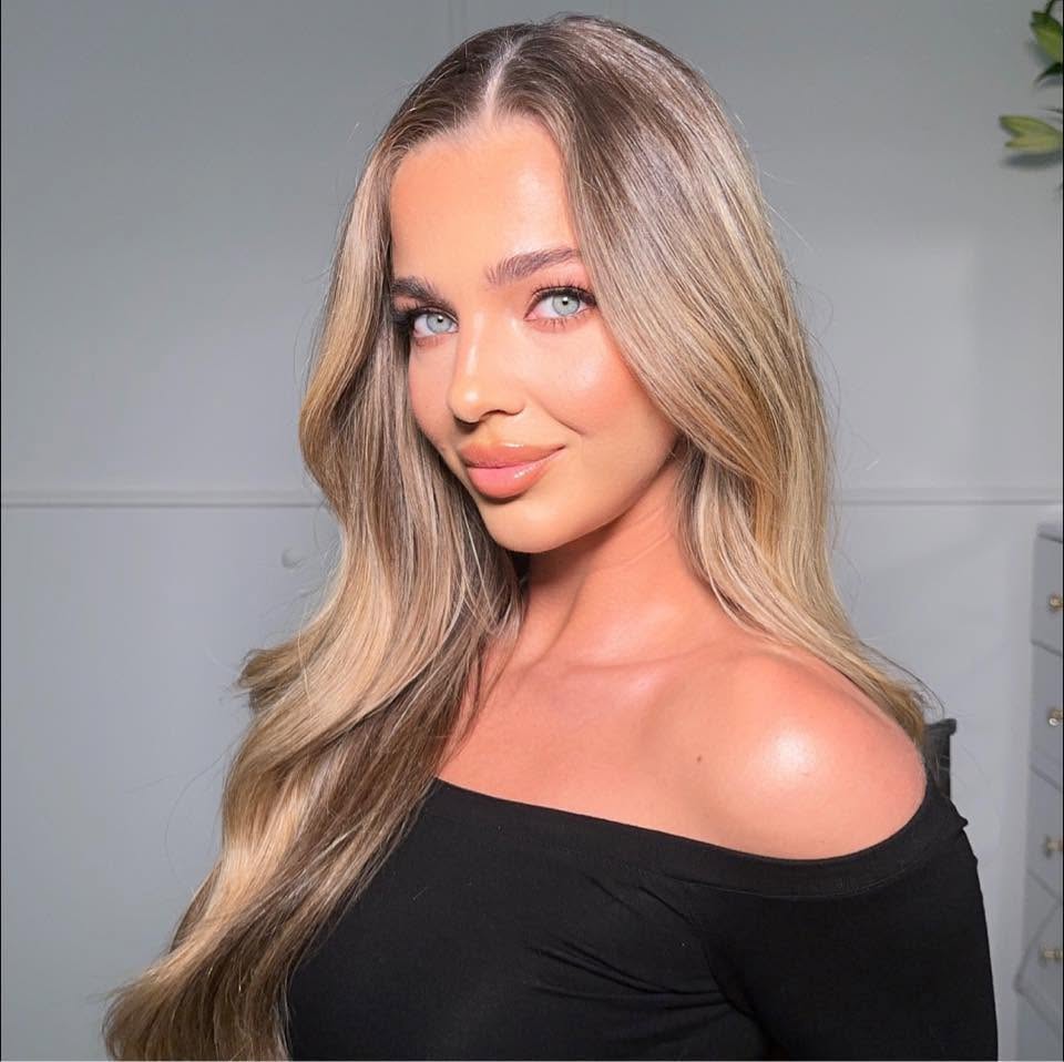 Oliwia Wołyniec, portret. Długie blond włosy, czarny top, jasne wnętrze.
